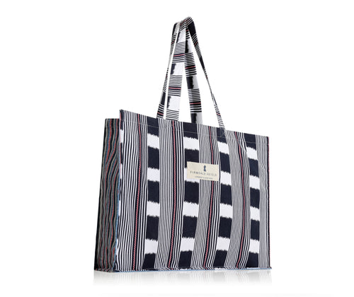 Our Bag for life is a large cotton bag, printed with Kit's Lost and found chequerboard print in navy and white, with pink ticking detailing , combined with the variegated stripes of Peace and love, in shades of blue, white and pink, in the gussets of the bag.