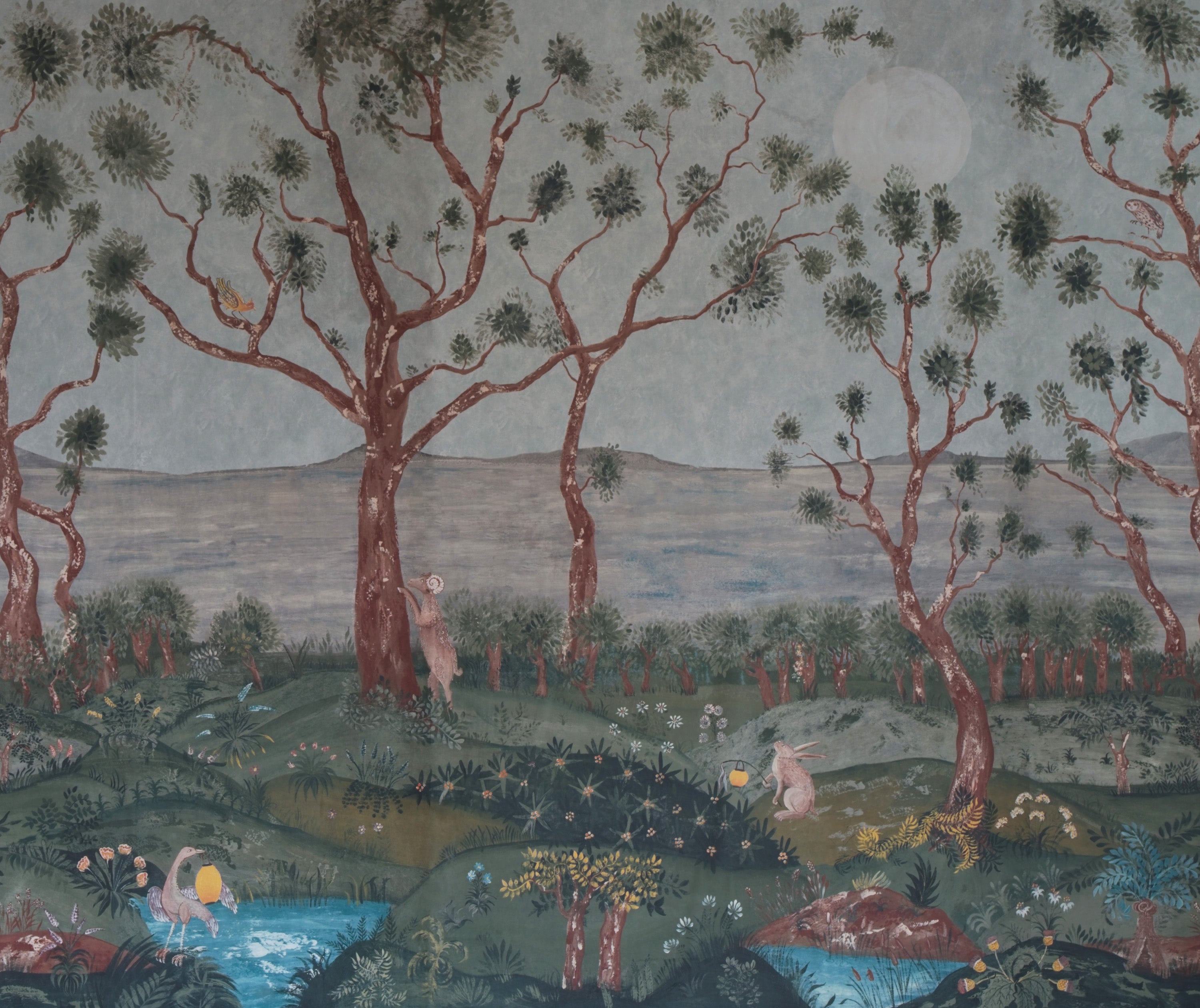 Kit Kemp's new Lantern Parade wall paper, in collaboration with Andrew Martin, takes elements from Tapestry Landscapes and medieval illumination to create an other-worldly treeline landscape, with the sea beyond. This forest landscape, in it's pale blue midsummer light is endlessly fascinating, revealing it's magic every time we look at it, with it's shy forest creatures, basking in dew drenched flowers, as if in the reflection of a lantern.
