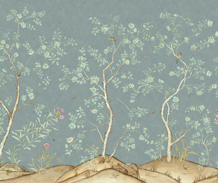 Kit's New Songbird Wallpaper, in collaboration with Andrew Martin, takes the stylised nature of Chinoiseries landscapes to a softer and more relaxed realm with an English twist. The Rain colourway is suffused in the blue/ green of an English rainy day, where a breeze ruffles the leaves of loosely painted trees dotted with dog roses. From the delicate branches, songbirds call to each other across this serene panorama.