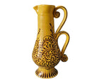 The Arabesque Double Handle Baluster Jug, by Katrin Moye is a hand thrown, yellow jug, hand painted with burgeoning chocolate plant life, growing up from the base, whose handle curls in a double looped arch.