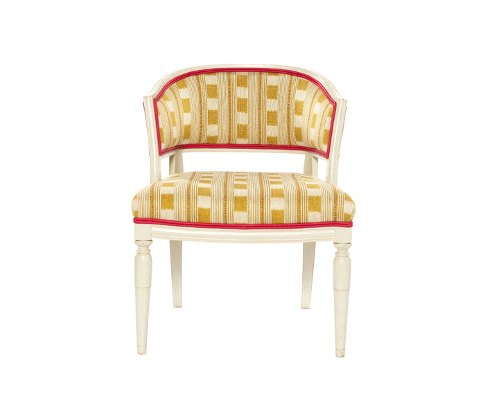 Front facing Whitby Chair in Lost and Found lemon fabric, showing hand carved solid wood legs in off white with a double pink leather trim