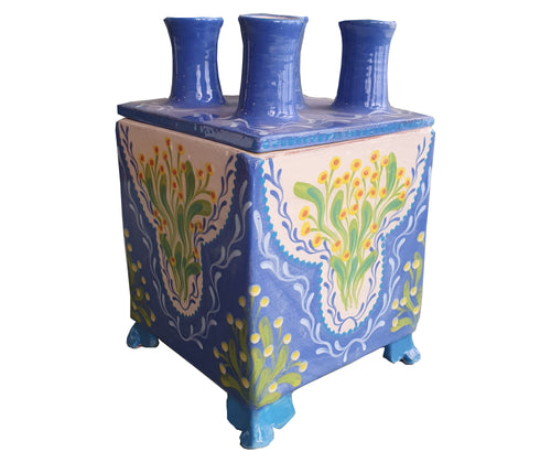 Katrin Moye's square spouted bud vase is hand painted in blue , and decorated with soft pastel flowers, in green, yellow and orange centres. It's box form, inspired by Tulipiere of old, is a modern take, which allows every individual flower its time t shine. 