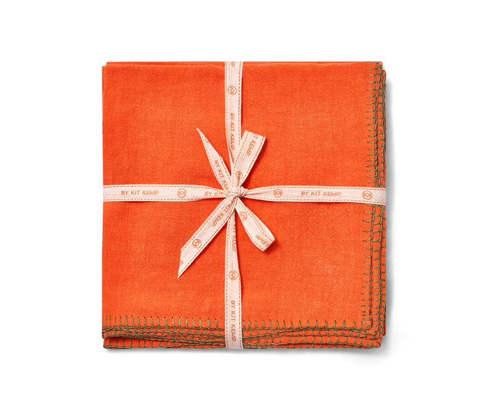 Beautifully soft Italian linen 50x50 napkins, deep orange linen hand-stitched in olive green blanket-stitching around the edges, sold in packs of 6. Shown tied with Kit Kemp ecru, and orange ribbon.