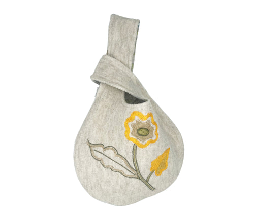 The Araminta Loop Bag is an embroidered wool, with simple floral design in yellow and green on an oatmeal base, lined in contrasting linen fabrics, in either Kit's green willow fabric, or yellow tea leaves, this loop bag is an ideal winter take on this unique design. 