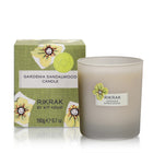 A round scented gardenia sandalwood candle in a glass frosted vessel and a packaging box with green friendly flowers design applied