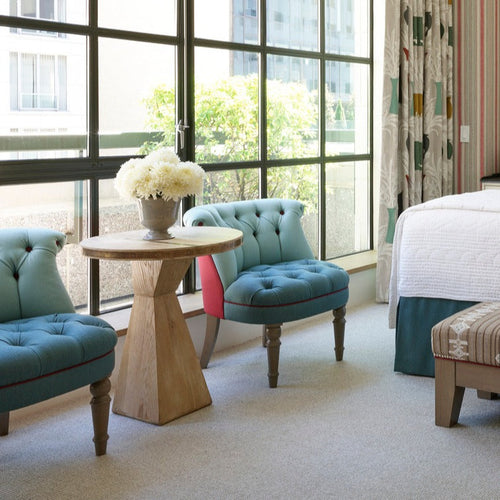 Kit Kemp circular ruler table between a pair of Stuart chairs 