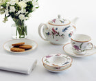 Picture of a table with teapot, teacup and strainer