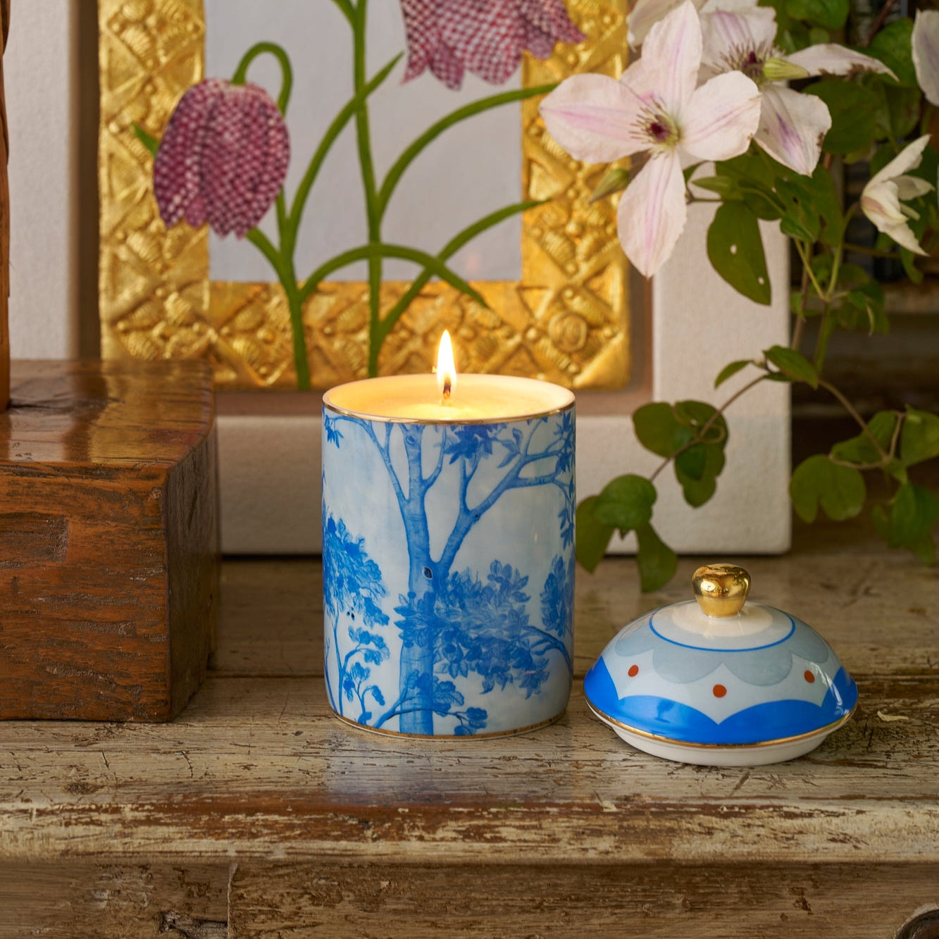 Kit Kemp Tall Trees blue and white ceramic candle with a floral pattern and a gold lid.