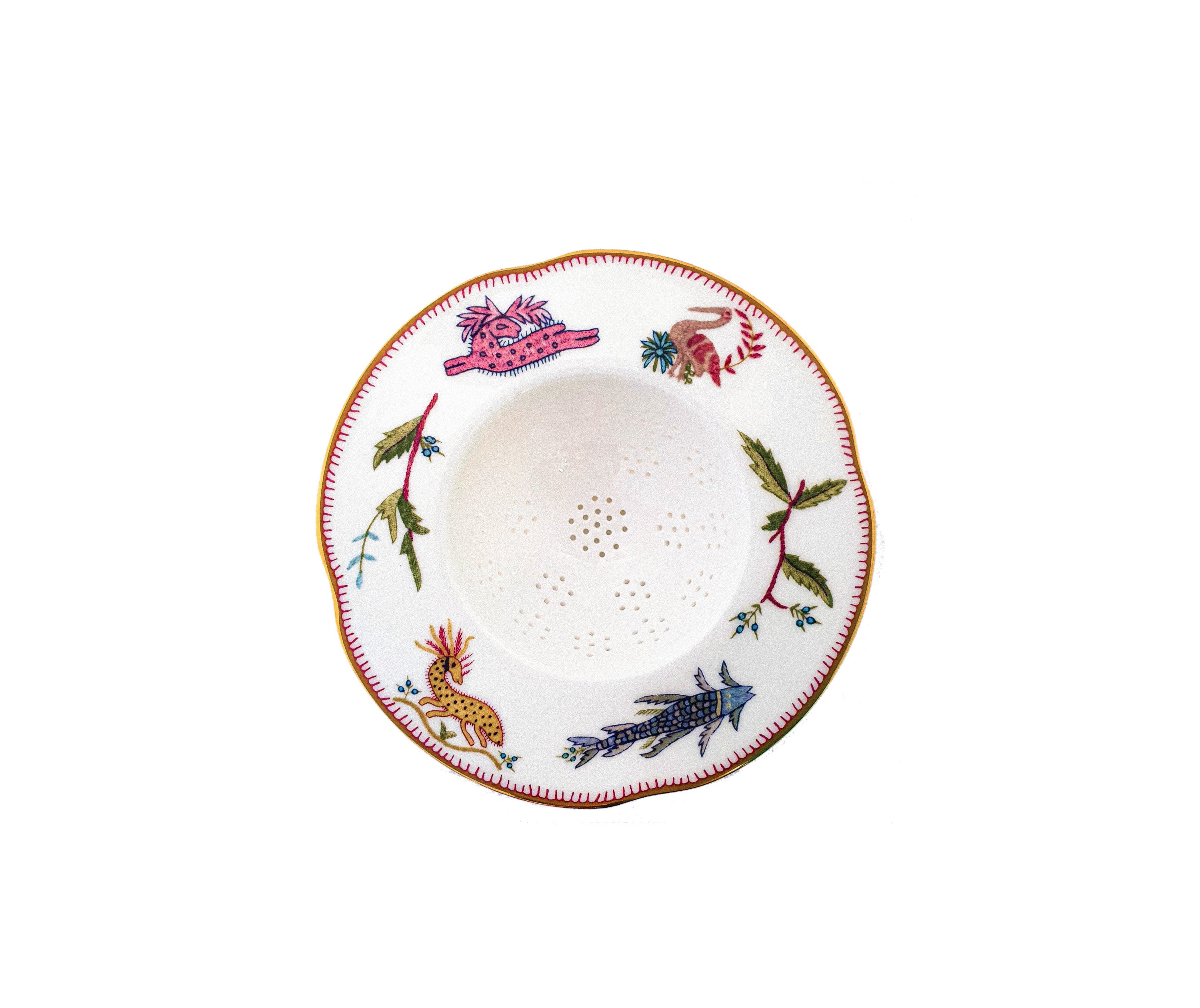 White Bone china tea strainer , with mythical creatures, including a pink antelope, yellow horse, and blue fish, view from above