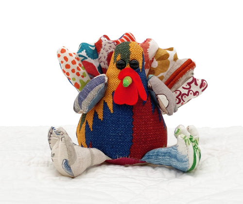 Our Shades of Autumn limited edition run of the Timothy Turkey patchwork toy, uses assorted re-purposed fabric, in various prints and textures to colours inspired by an autumn trees, from greens, yellows , reds and rust browns. Each handmade toy is individual. This one has a rich rust and blue body, and a fan like tail of assorted orange toned fabrics. Size when sitting:15cm x10cm