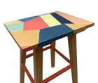 A view from above of the small hand painted table takes its inspiration from Kit's Zig Zag fabric with Christopher Farr, with its bold abstract rectangles painted in pale yellow, blue , peach and red, on the table top and pale orange legs, makes for a striking occasional table to site beside your favourite chair.