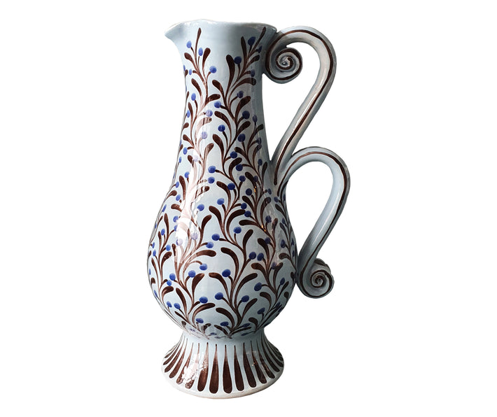 The Upright Double Handle Baluster Jug , by Katrin Moye is hand thrown, pale wedgewood blue jug, hand painted with blue berried plant life, and is a beautifully practical addition to any dining table.