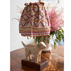 A life style photo of the Doggy lamp on a antique marquetry table , in front of a pink astilbe floral display.