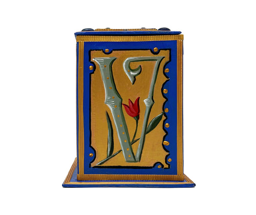 This bright blue and gold alphabet box is decorated with a grey letter V in a heraldic decorative style, surrounded by a gold, is bejewelled in blue and gold faux gemstones. 