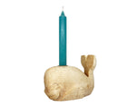 This hand carved sycamore whale candlestick is viewed facing the left, dressed with blue candle.